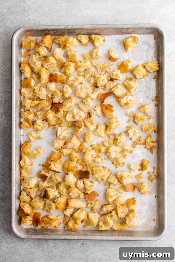 Homemade Caesar Salad Recipe with Classic Parmesan Dressing 4 Top down view of croutons on a baking sheet.