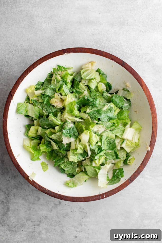 Homemade Caesar Salad Recipe with Classic Parmesan Dressing 6 Top down view of salad in a mixing bowl.