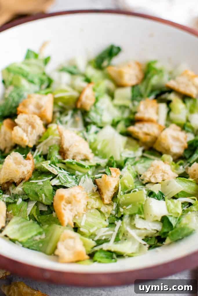 Homemade Caesar Salad Recipe with Classic Parmesan Dressing 7 Close up view of Caesar salad with dressing and croutons.