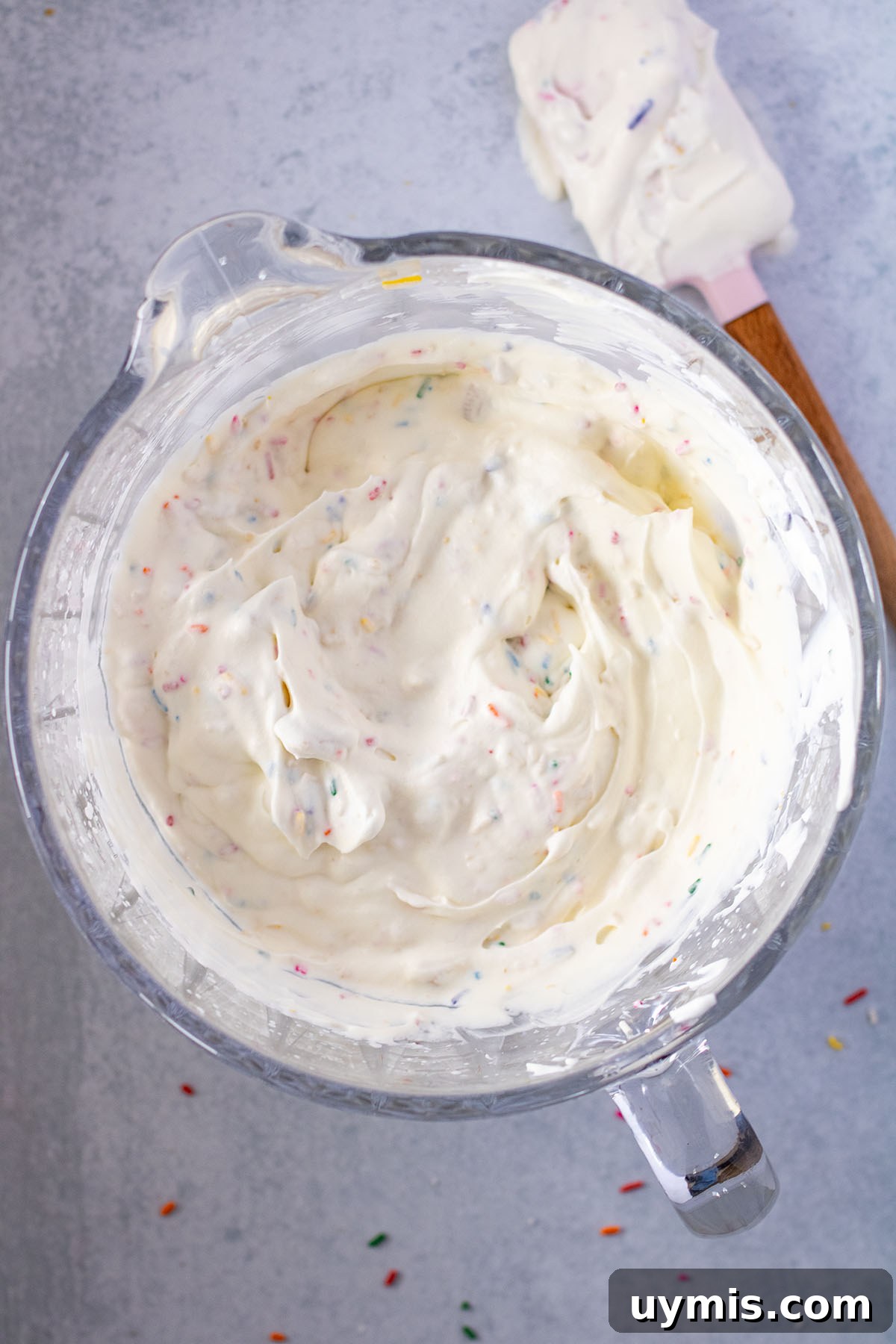 No-Churn Funfetti Golden Oreo Ice Cream Recipe 7 Chopped Oreos and sprinkles folded into ice cream in mixing bowl.
