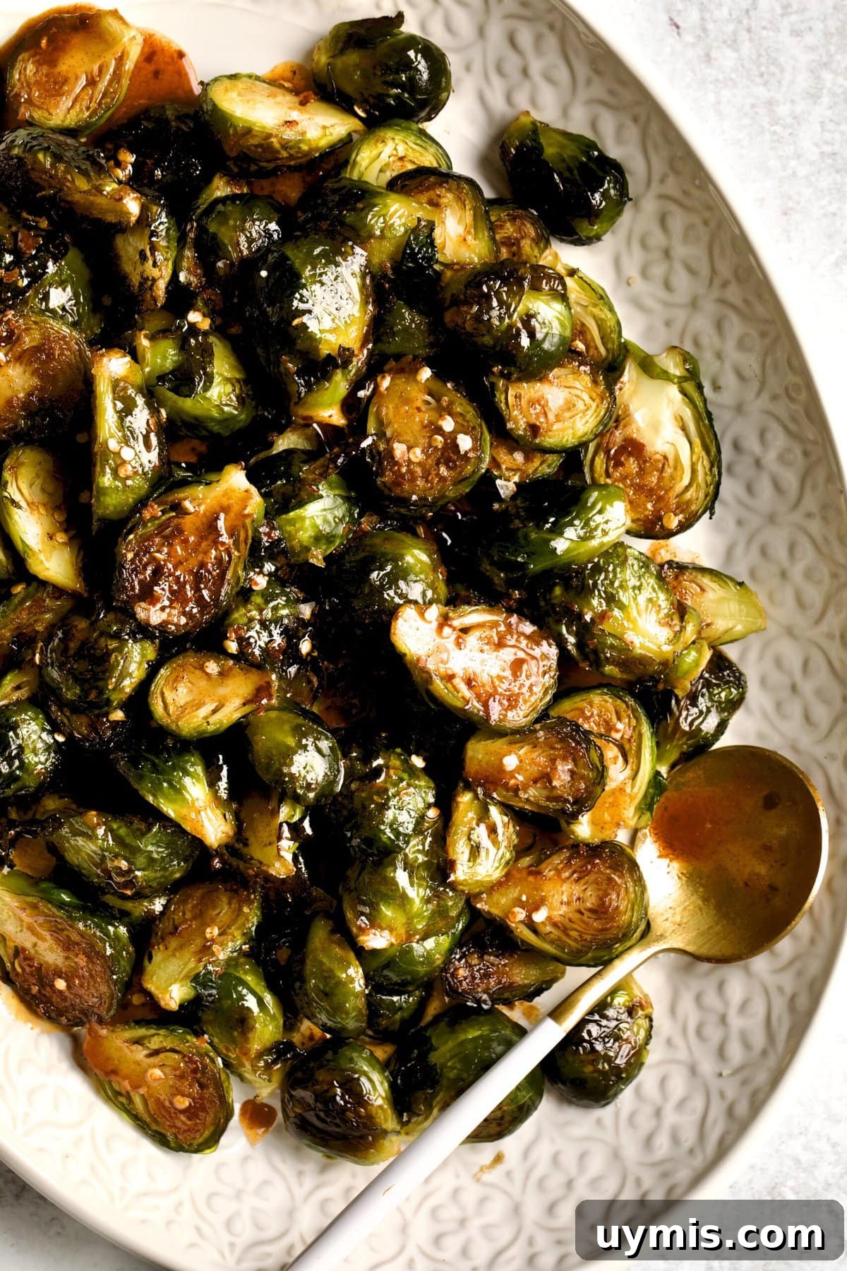 LongHorn Steakhouse Copycat Crispy Brussels Sprouts Recipe 2 Crispy Brussels Sprouts Recipe on a cream colored serving platter.