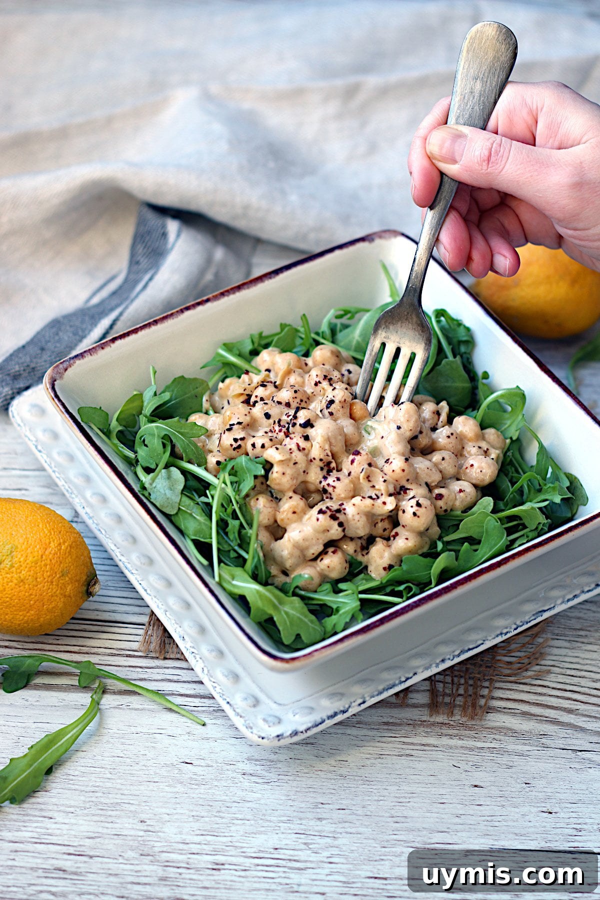 Sesame Steak Sauce Recipe Sawmill Copycat 7 A fork scooping from a bowl of Lazy Chickpea Salad over arugula.
