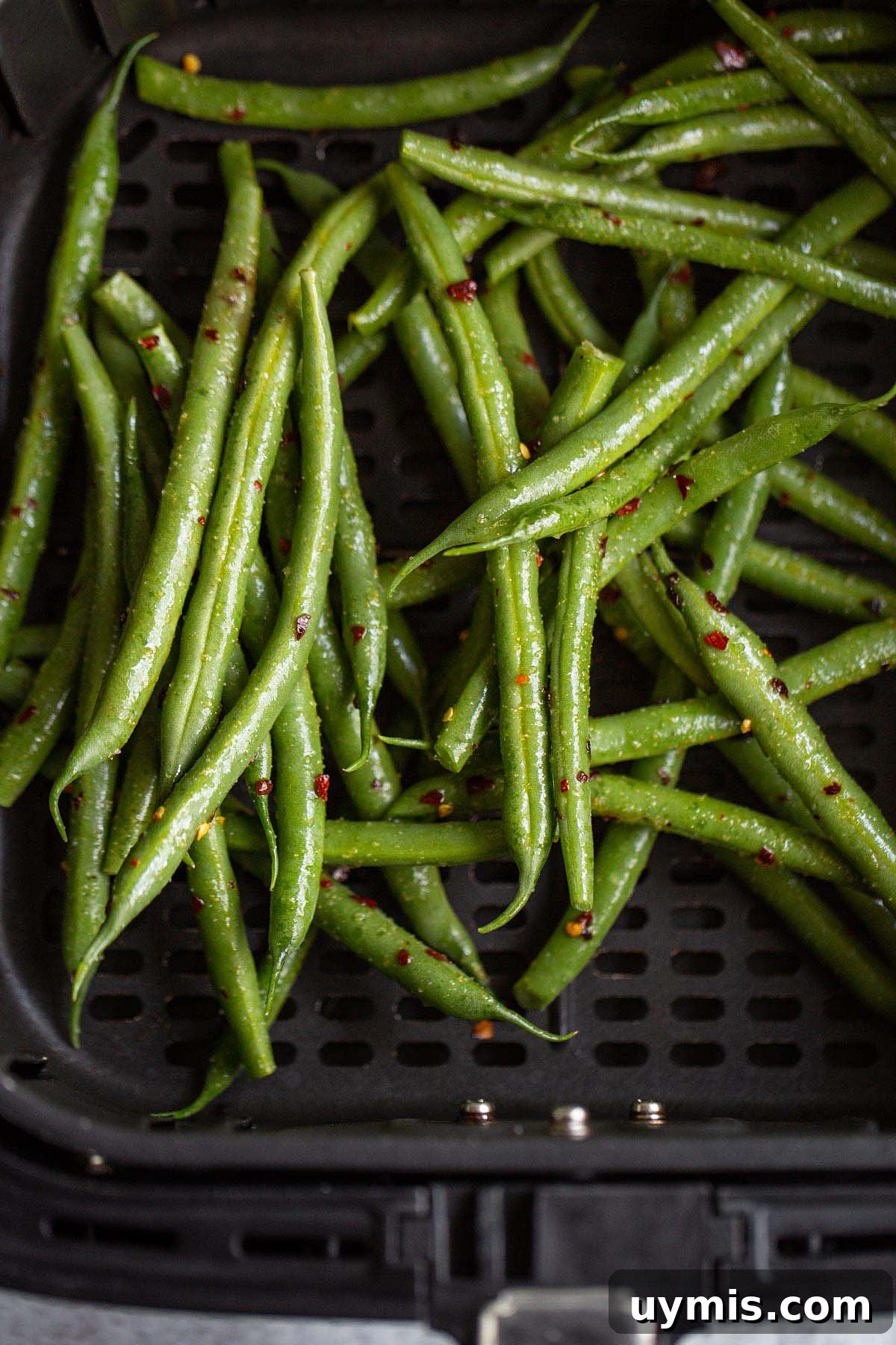 Crispy Spicy Air Fryer Green Beans 6 Uncooked green beans in air fryer basket