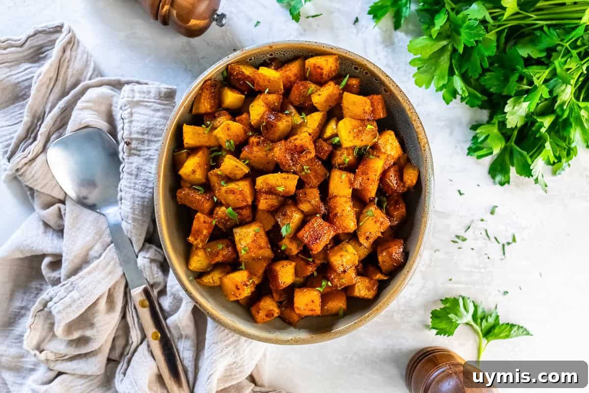 Spiced Roasted Butternut Squash Recipe 6 spiced roasted butternut squash in a bowl, garnished with parsley and surrounded by rustic linens and herbs.