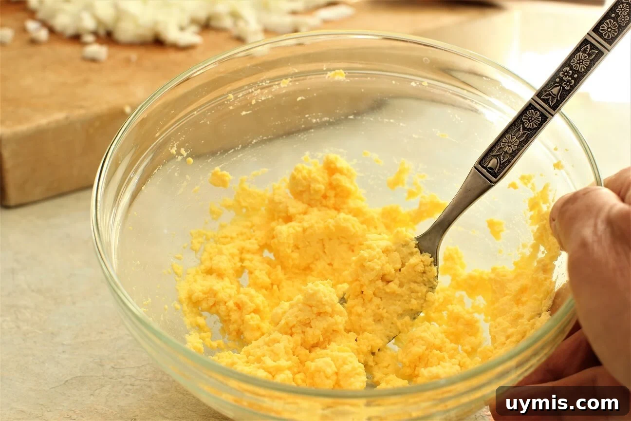 Spring Chive and Egg Pasta Salad Recipe 12 Mashing boiled egg yolks with a fork for the Chive & Egg Pasta Salad
