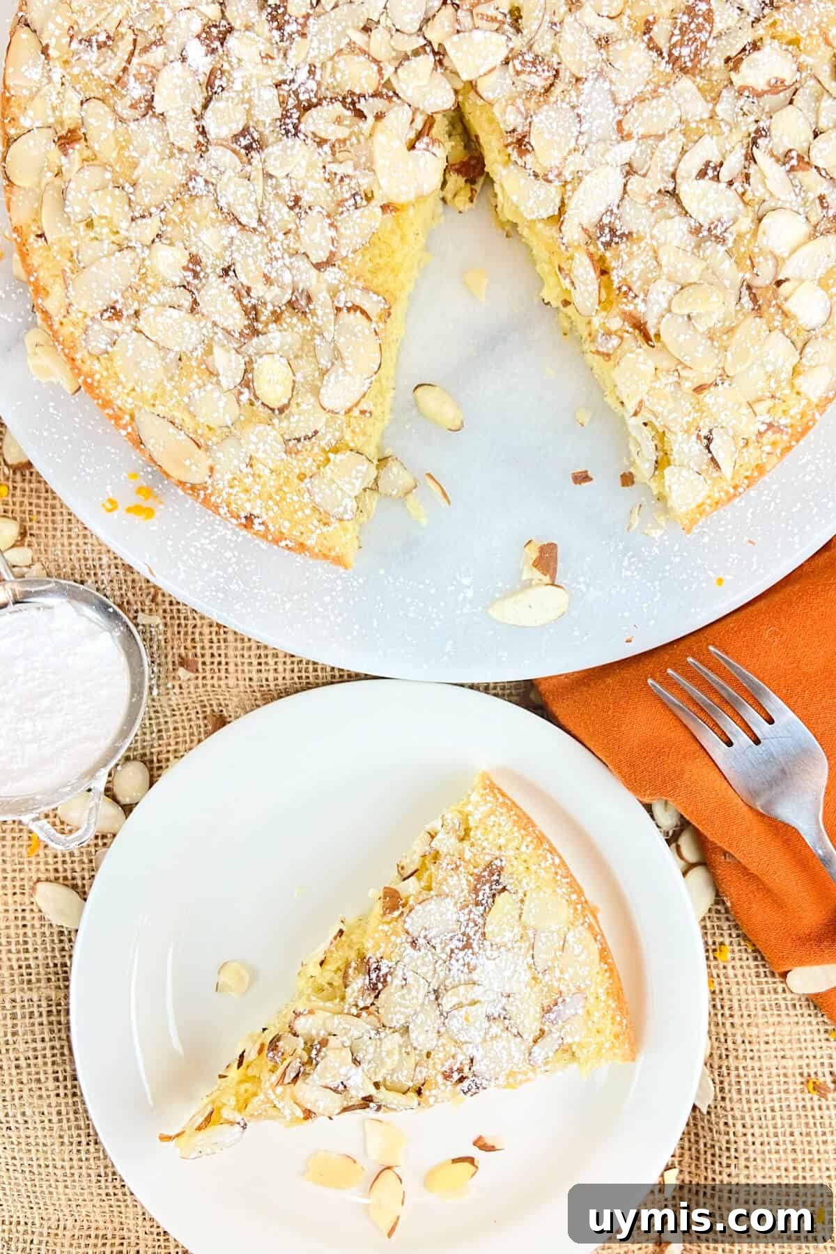 Italian Almond Cake Recipe with Tender Crumb 3 Whole cake, with slice of cake plated.