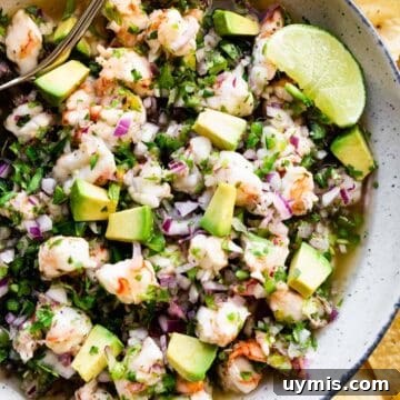 shrimp ceviche in a bowl with avocado and limes