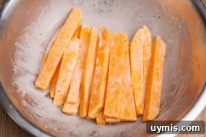 Crispy Air Fryer Sweet Potato Fries 10 Cornflour coated sweet potato fries in a bowl