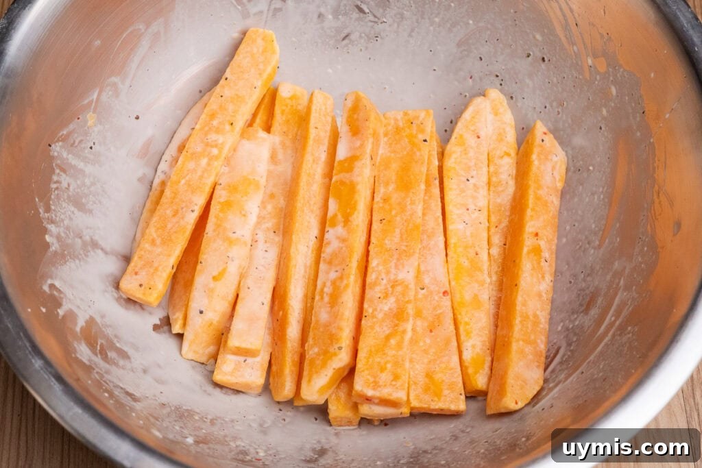 Crispy Air Fryer Sweet Potato Fries 27 Cornflour coated sweet potato fries in a bowl
