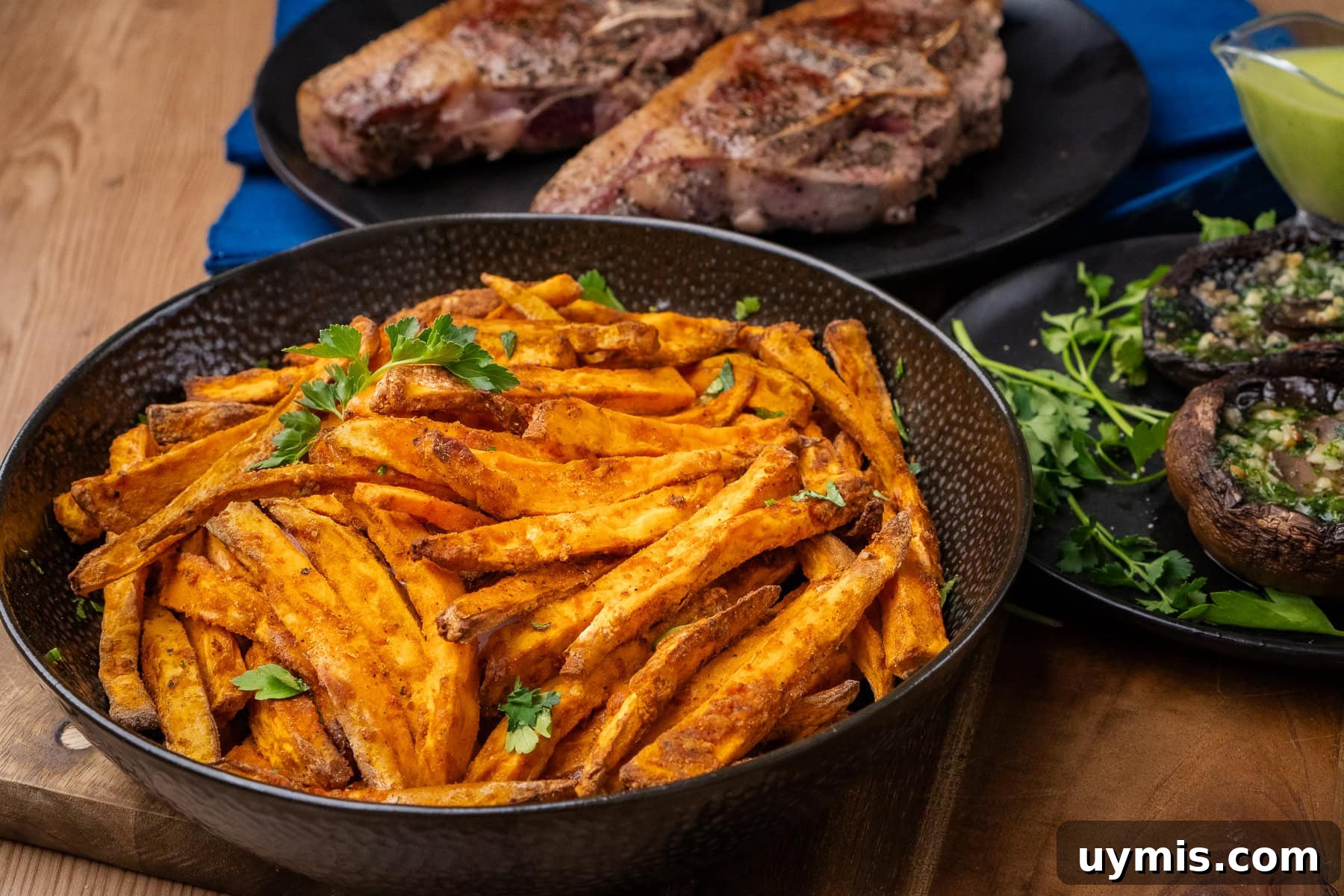 Crispy Air Fryer Sweet Potato Fries 32 Air Fryer Sweet Potato Fries served in a bowl with air fryer garlic mushrooms and Barnsley chops served on the side