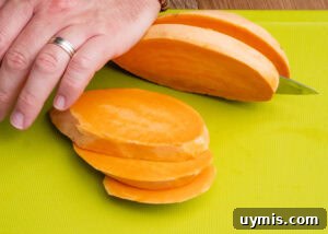 Crispy Air Fryer Sweet Potato Fries 4 Slicing a sweet potato with a sharp knife on a green chopping board