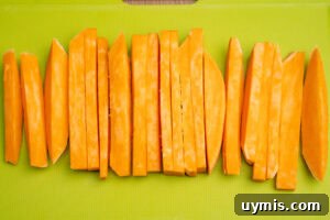 Crispy Air Fryer Sweet Potato Fries 5 Par boiled sweet potato fries on a green chopping board