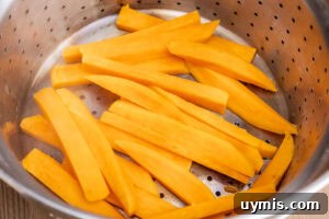 Crispy Air Fryer Sweet Potato Fries 7 Sweet Potato Fries in a drainer