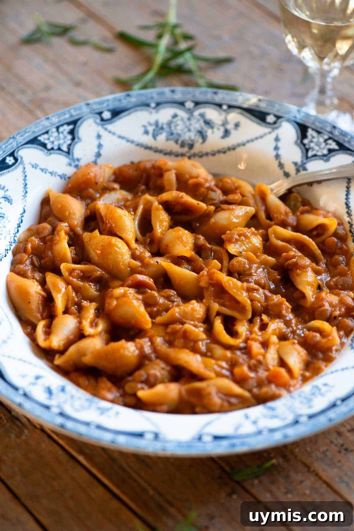 Pasta e Lenticchie Italian Pasta and Lentils Recipe 6 A close up of pasta and lentils in a blue vintage style bowl with a spoon.