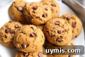 Pumpkin Chocolate Chip Cookies Made with Cake Mix 8 large pumpkin chocolate chip cookies on a white plate