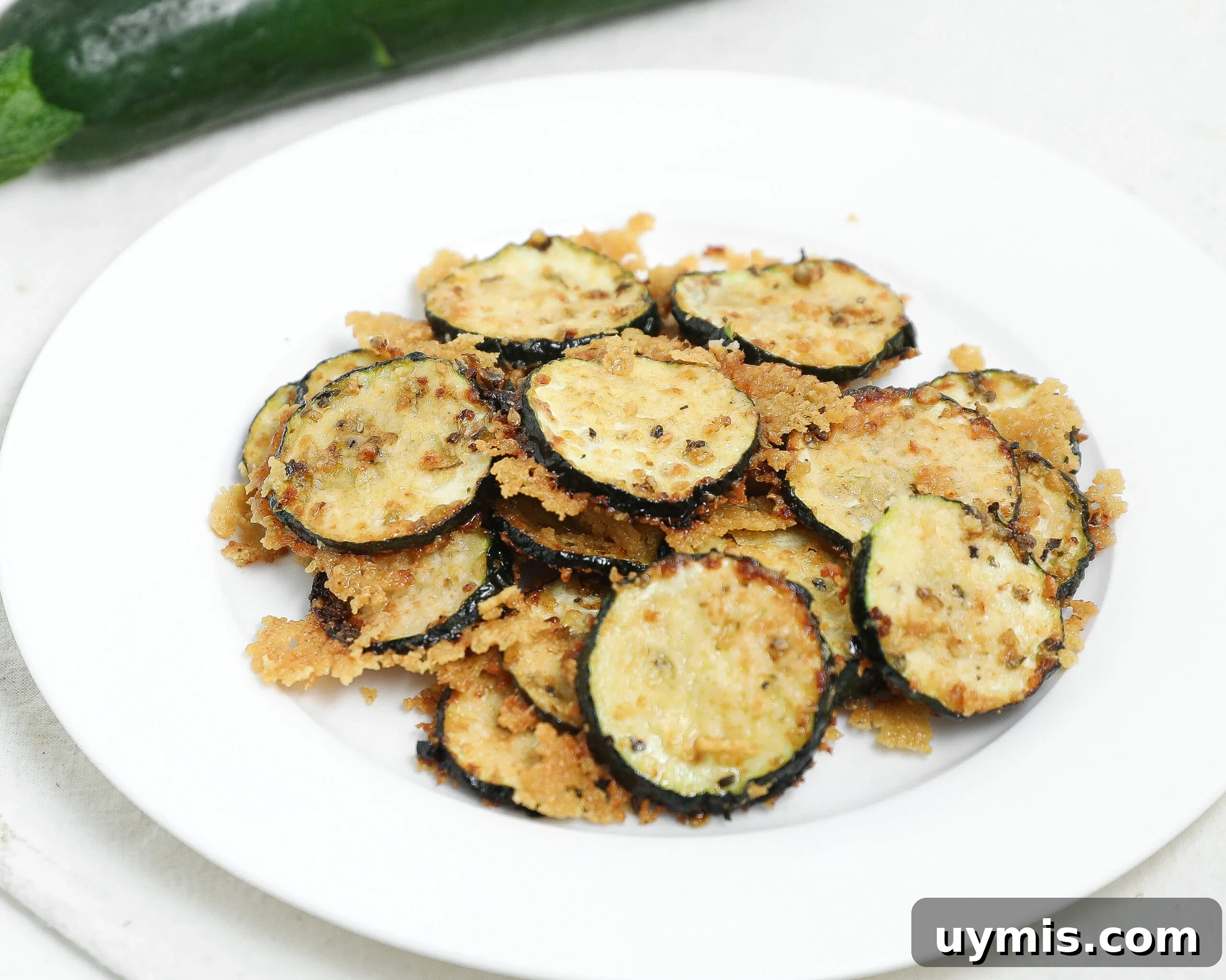 Maple Roasted Sweet Potatoes with Bacon and Walnuts 7 Roasted zucchini slices topped with parmesan cheese on a white plate.
