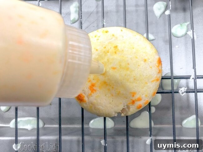 Zesty Orange Juice Cookie Recipe with Citrus Glaze 6 squeezing icing onto orange cookies