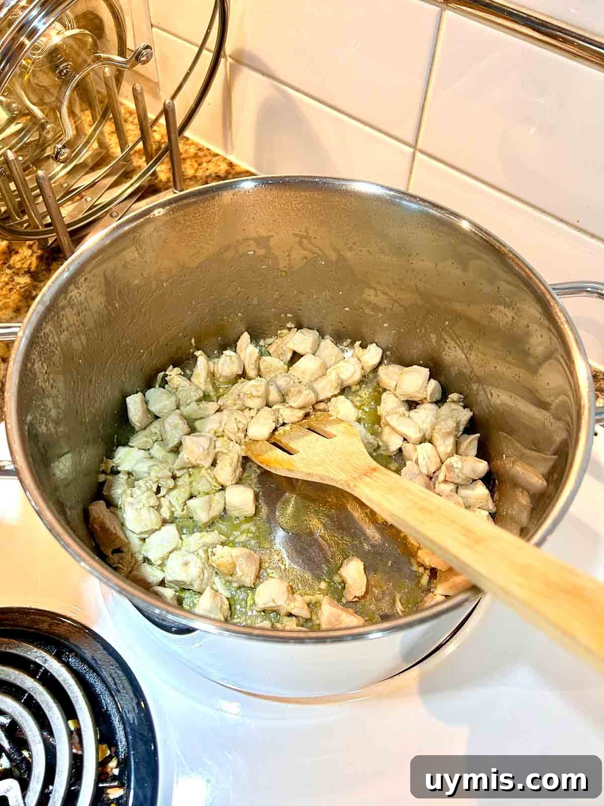 Creamy One Pot Chicken and Broccoli Pasta 4 chicken breasts being sautéed in pot.