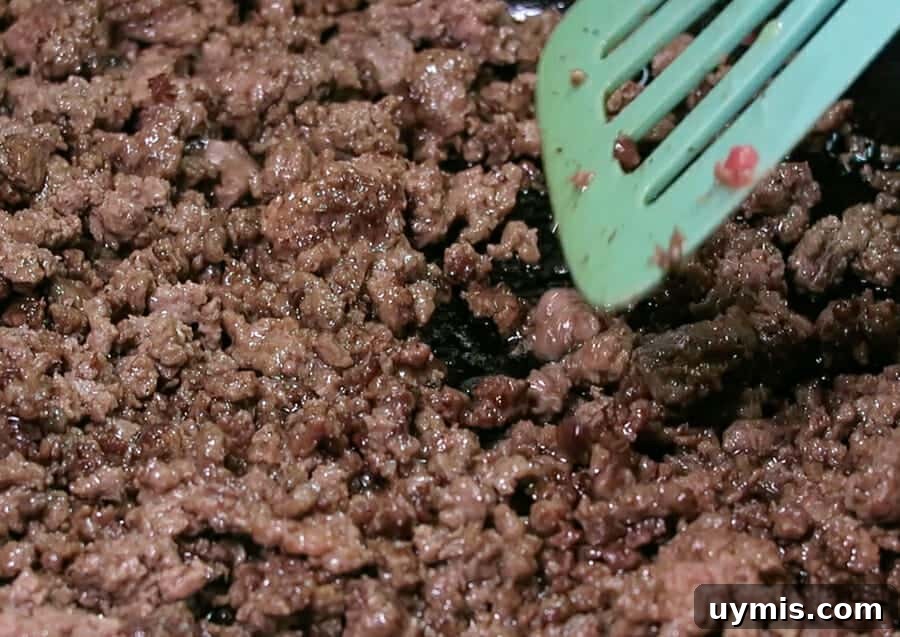 Creamy Ground Beef Stroganoff with Greek Yogurt 5 Cooking ground beef in a large cast iron skillet for Ground Beef Stroganoff