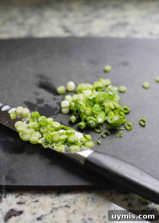 Boursin Garlic and Herb Buttermilk Biscuits Recipe 4 Chopped green onions on a cutting board.