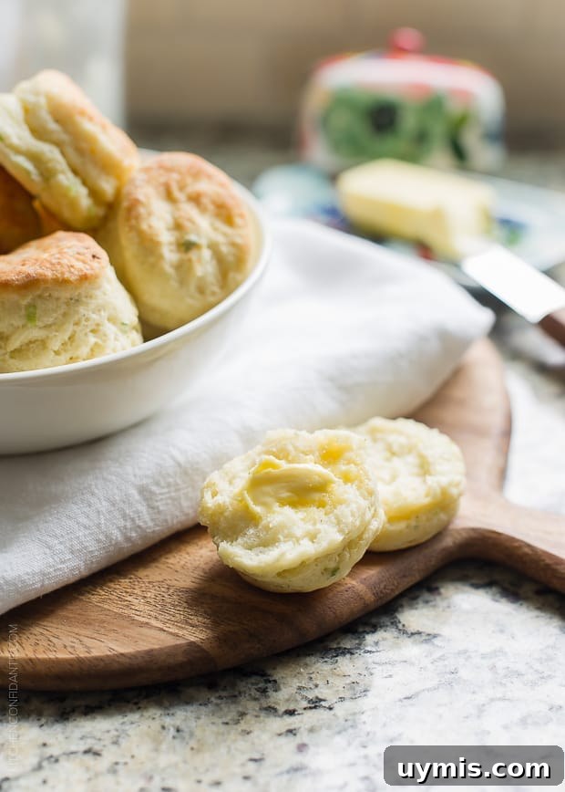 Boursin Garlic and Herb Buttermilk Biscuits Recipe 8 A biscuit broken in half and spread with butter.