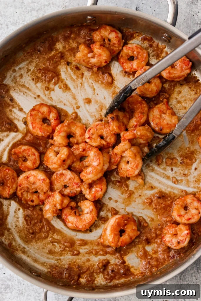 Asian Chili Garlic Shrimp - Paleo Whole30 Recipe 3 Stir frying shrimp with sauce in a pan