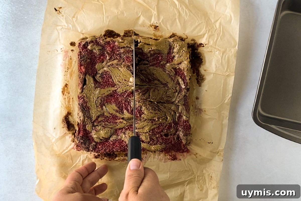 SunButter and Jelly Brownies 6 hand slicing SunButter & Jelly Brownies on parchment paper