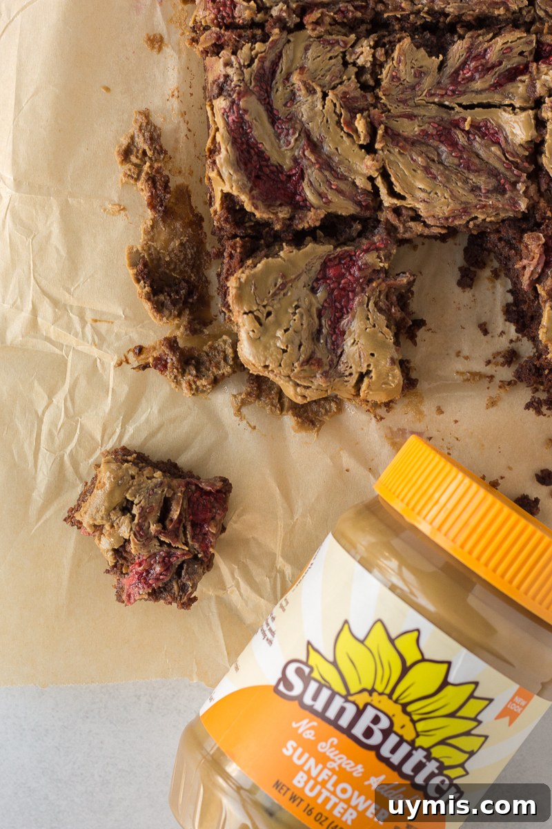 SunButter and Jelly Brownies 8 SunButter & Jelly Brownies cut into squares on parchment paper with a knife