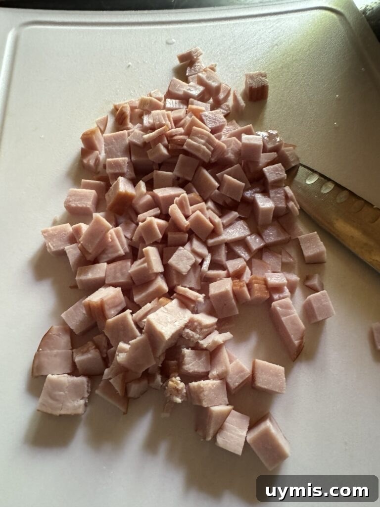 Baked Eggs Benedict Hash Brown Casserole 5 Sliced Canadian bacon on a cutting board.
