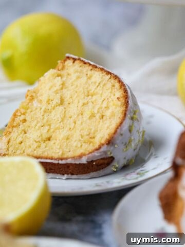 Slice of moist lemon Bundt cake on a white plate.