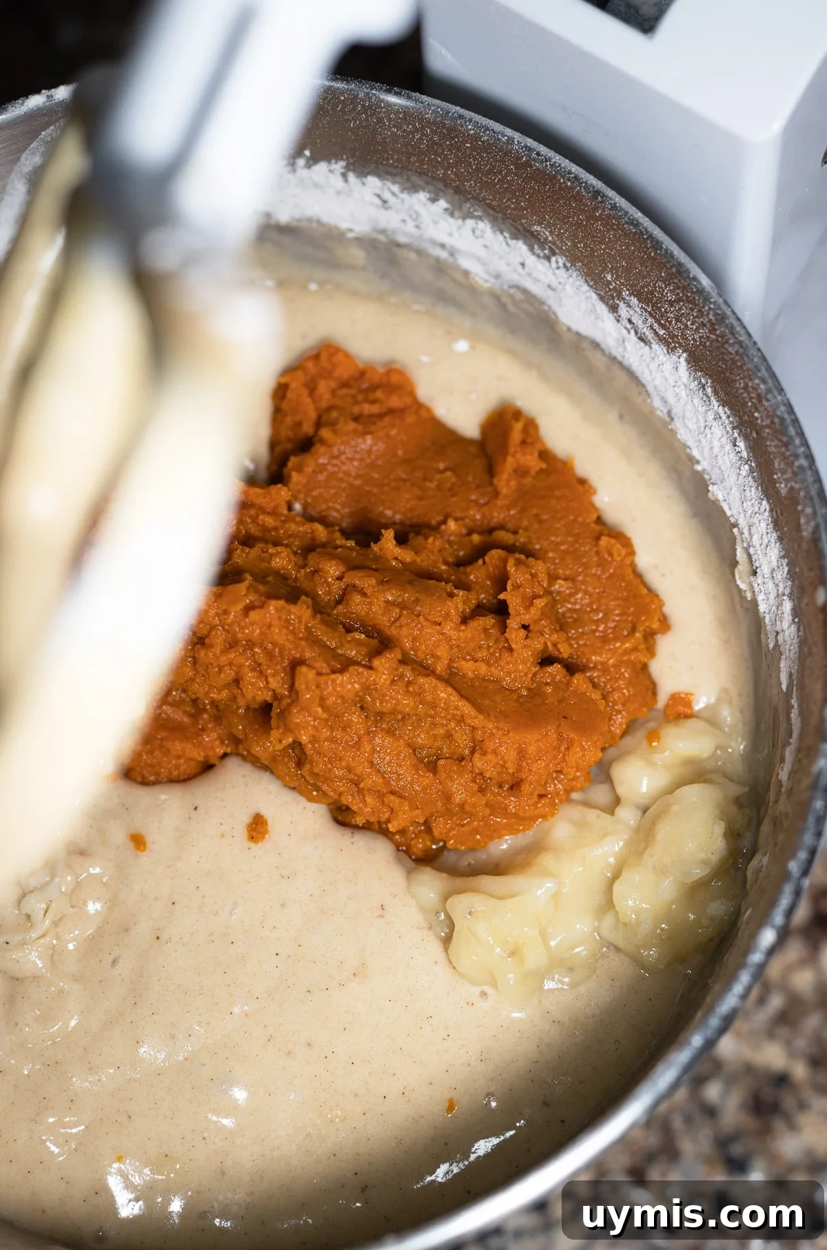 Pumpkin and mashed banana being added to bread batter.