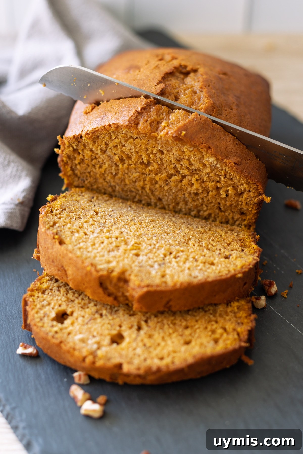 Person slicing pumpkin banana bread.
