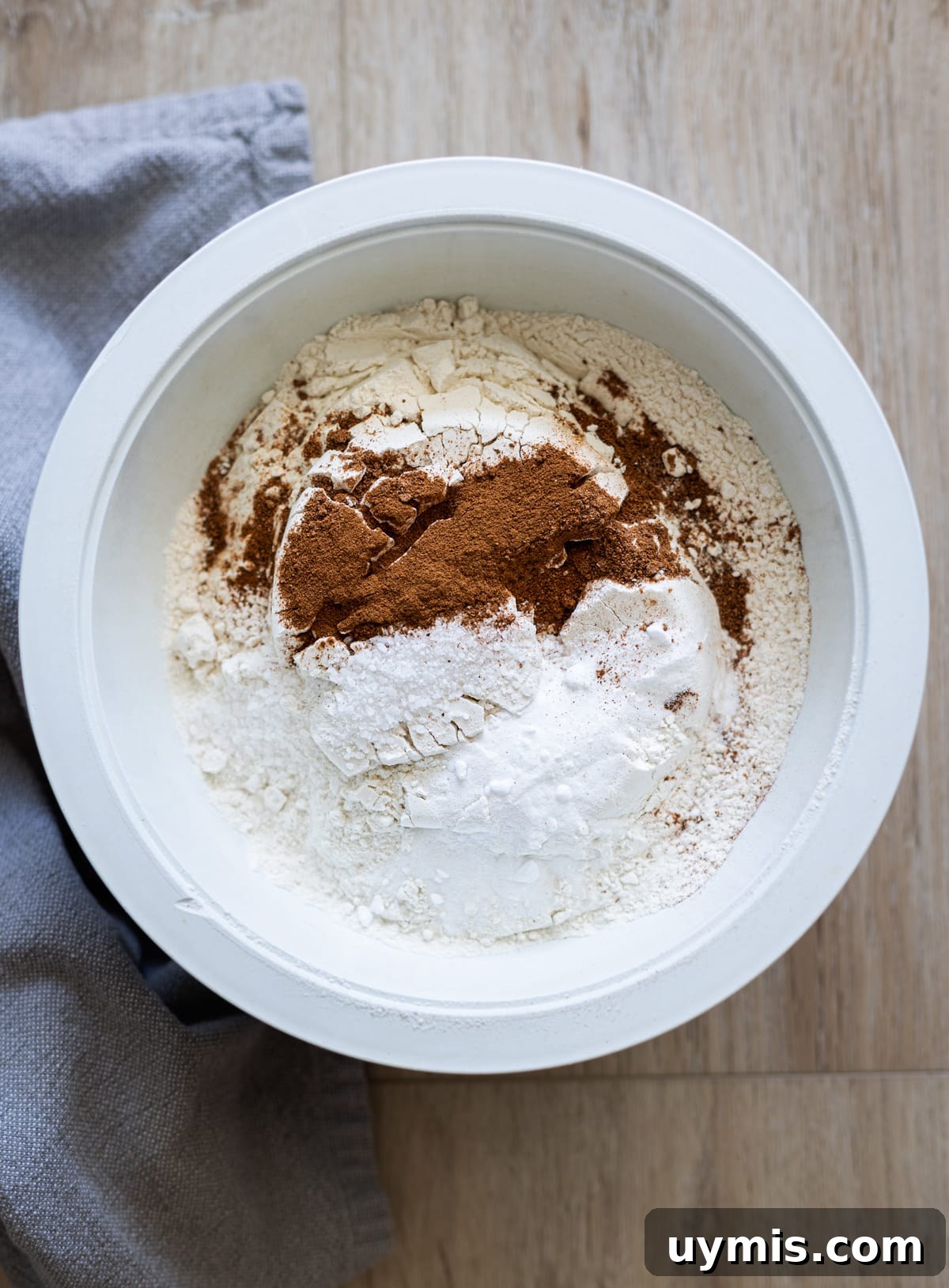 Bowl containing flour, baking soda, salt, cinnamon and nutmeg.