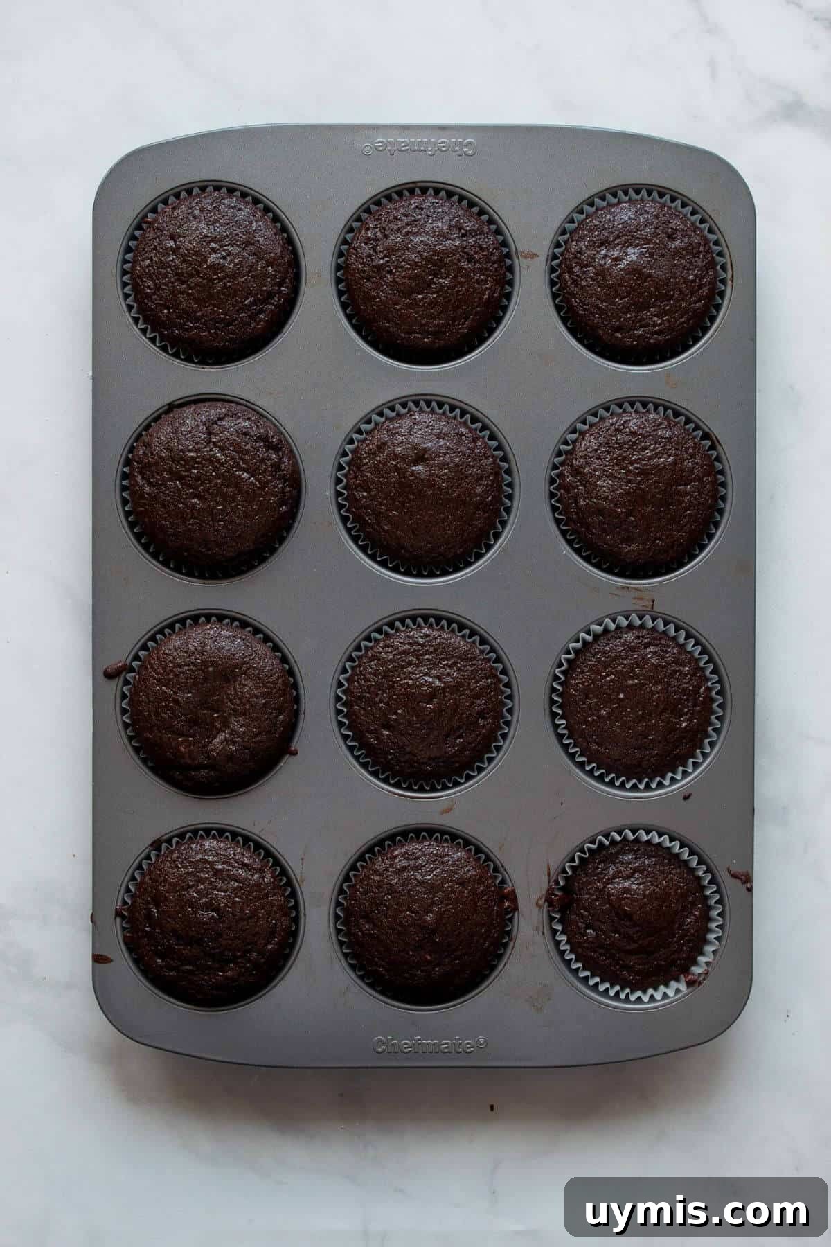 Fudgy Gluten Free Chocolate Cupcakes Recipe 7 Baked gluten-free chocolate cupcakes cooling in a muffin tin.