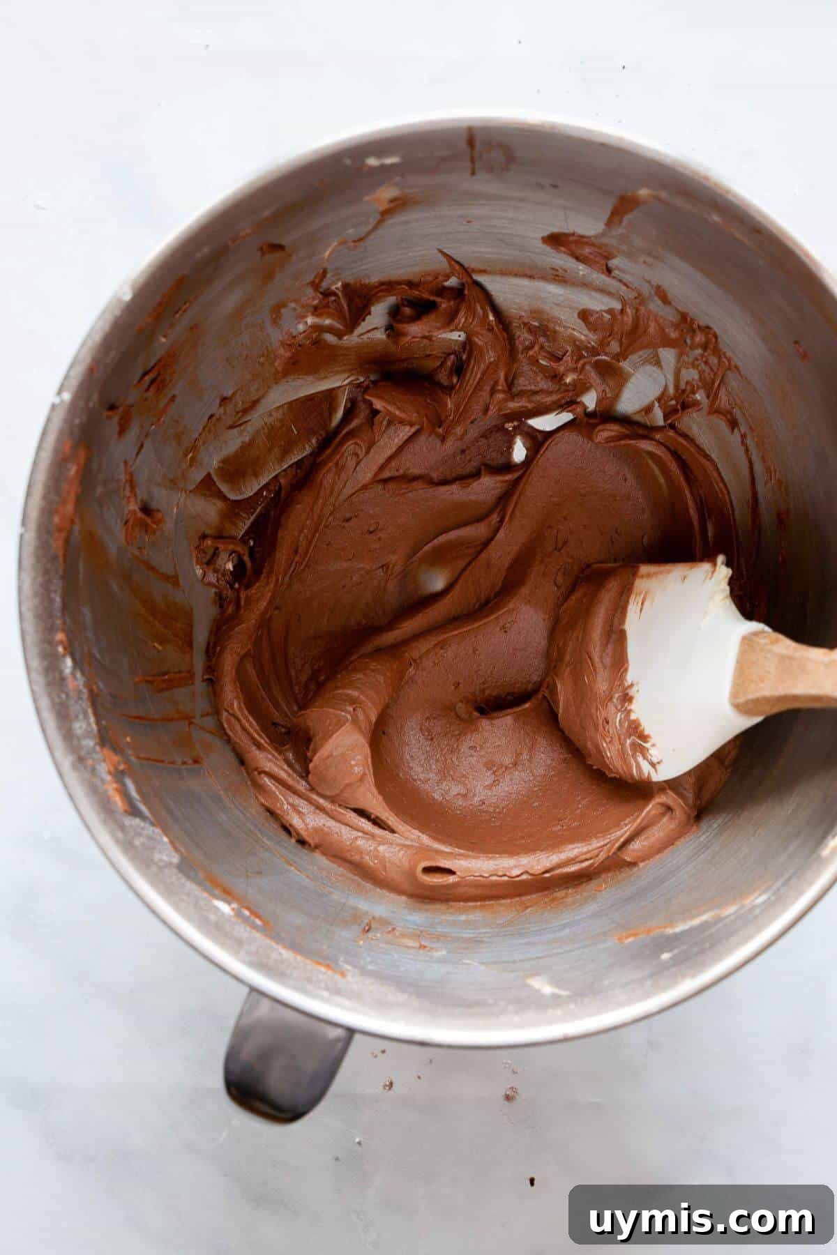 Fudgy Gluten Free Chocolate Cupcakes Recipe 8 Dairy-free chocolate buttercream frosting being mixed with a spatula.