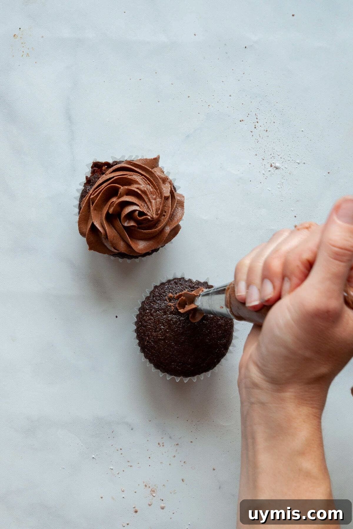 Fudgy Gluten Free Chocolate Cupcakes Recipe 9 Piping dairy-free chocolate frosting onto a gluten-free chocolate cupcake by hand.