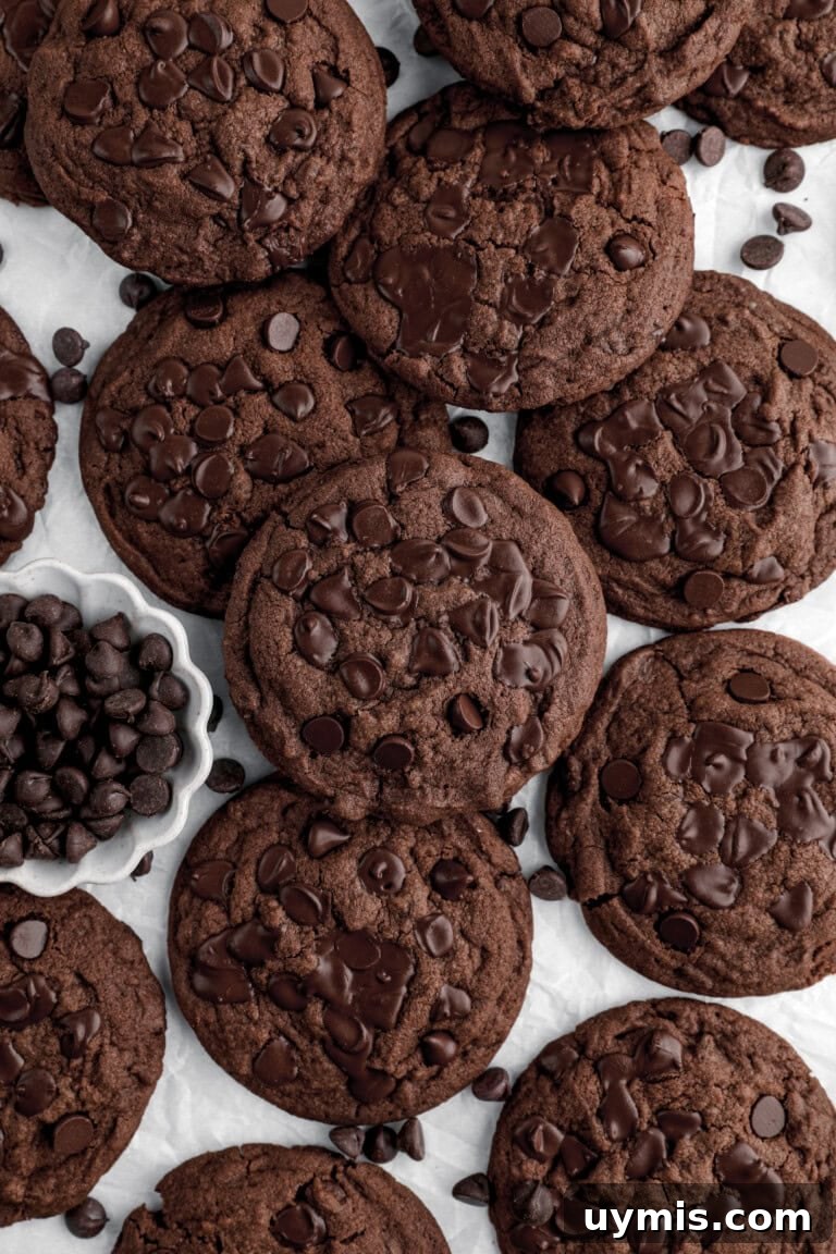 double chocolate chip cookies piled on parchment paper.
