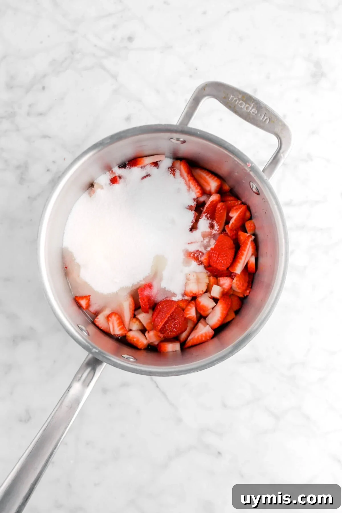 sugar, lemon juice, and chopped strawberries in a pot.