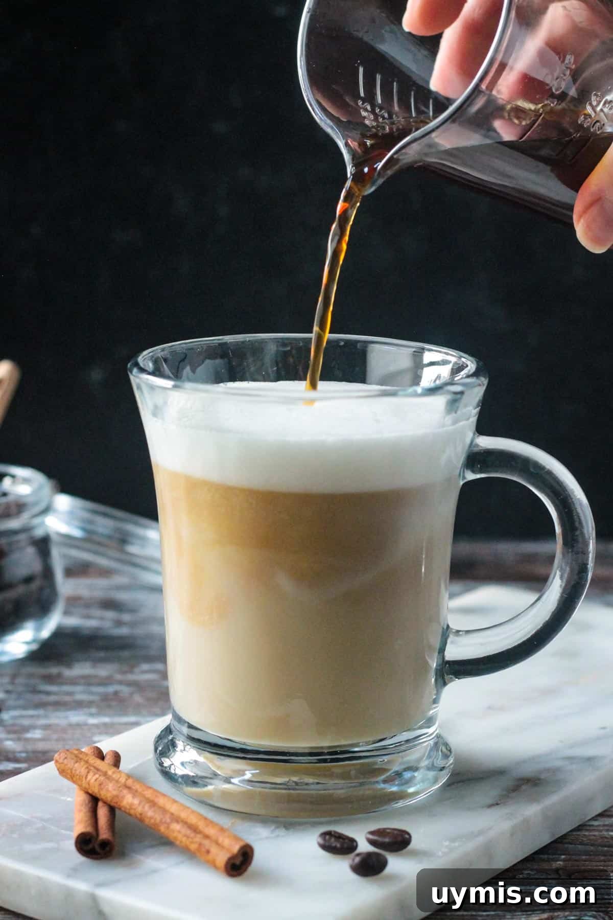 Pouring espresso into a creamy coffee drink.