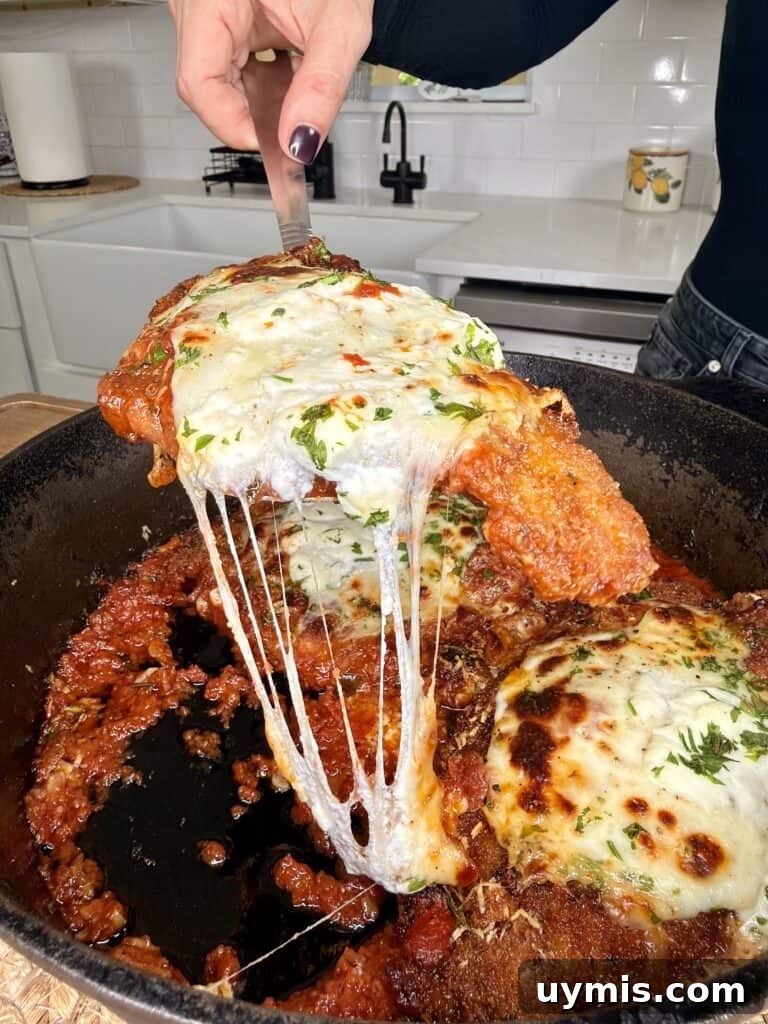 Why I Switched to Caraway Cookware: One-Pan Dinner for Two 9 A hand lifts a cheesy, breaded chicken cutlet covered in marinara sauce and melted mozzarella.