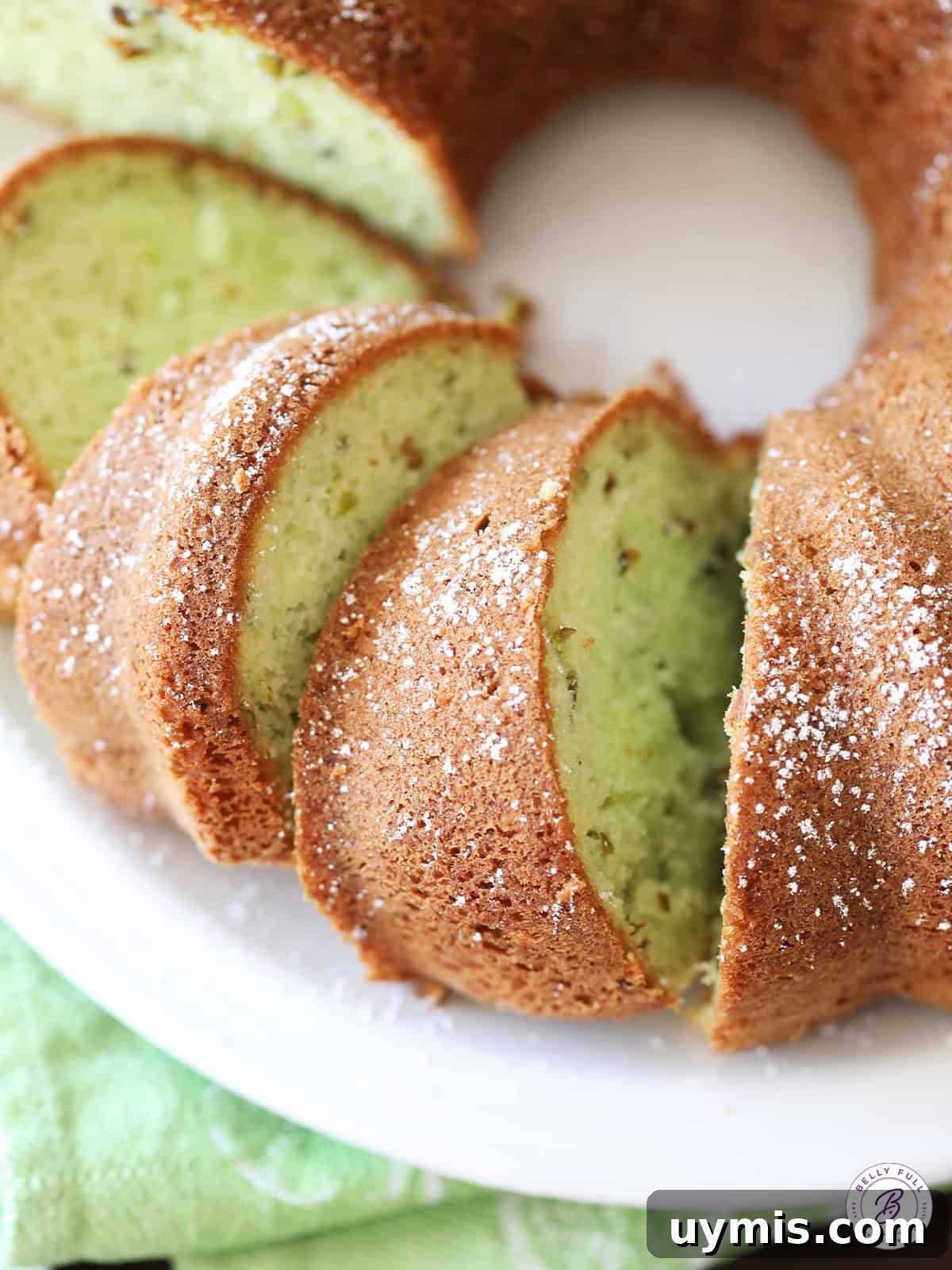 Pistachio Cake Recipe: Moist, Nutty & Irresistible 2 sliced Pistachio Cake on serving plate