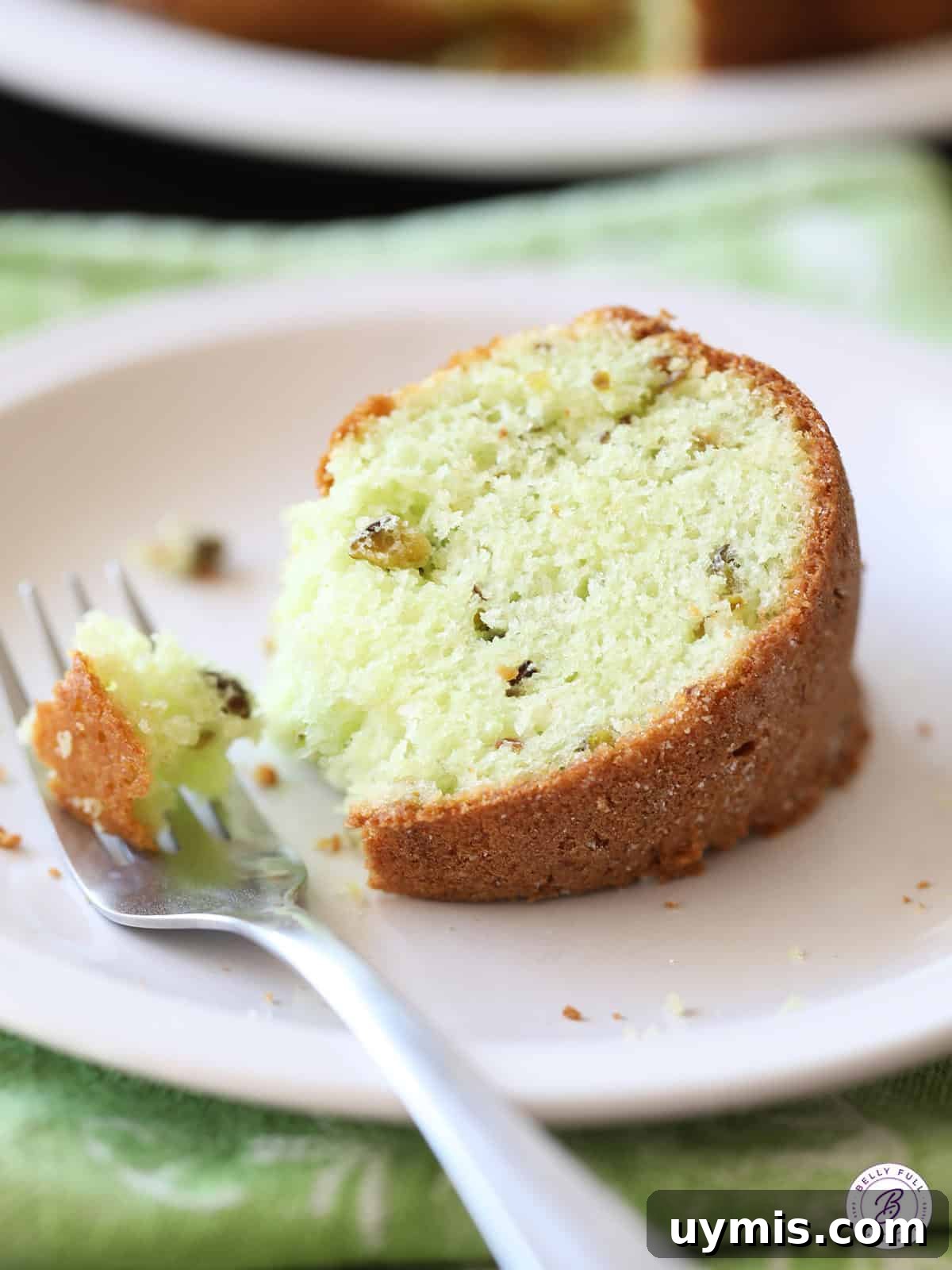 Pistachio Cake Recipe: Moist, Nutty & Irresistible 4 a slice of Pistachio Cake on plate with fork