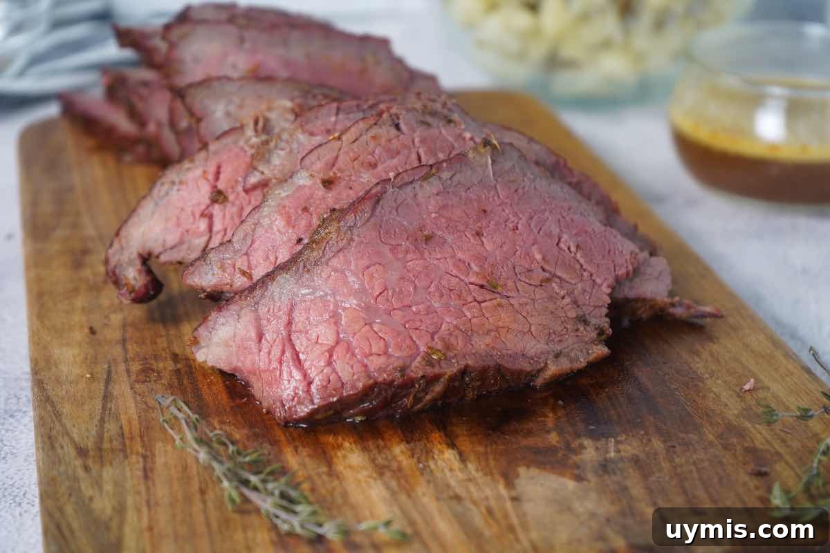Smoked Rump Roast with Thyme Rub 3 Smoked rump roast sliced with au jus behind and fresh thyme sprigs around it.