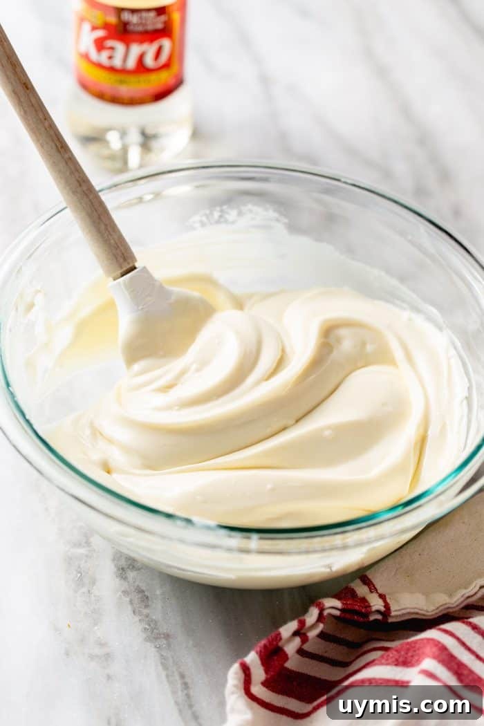 Spatula stirring no-bake cheesecake bar filling in a glass mixing bowl