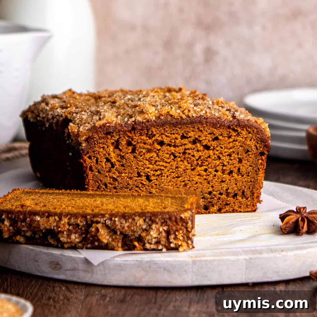 Moist Pumpkin Bread Recipe with Warm Spices 3 front view of a loaf of Healthy Pumpkin Bread with a slice cut out of it