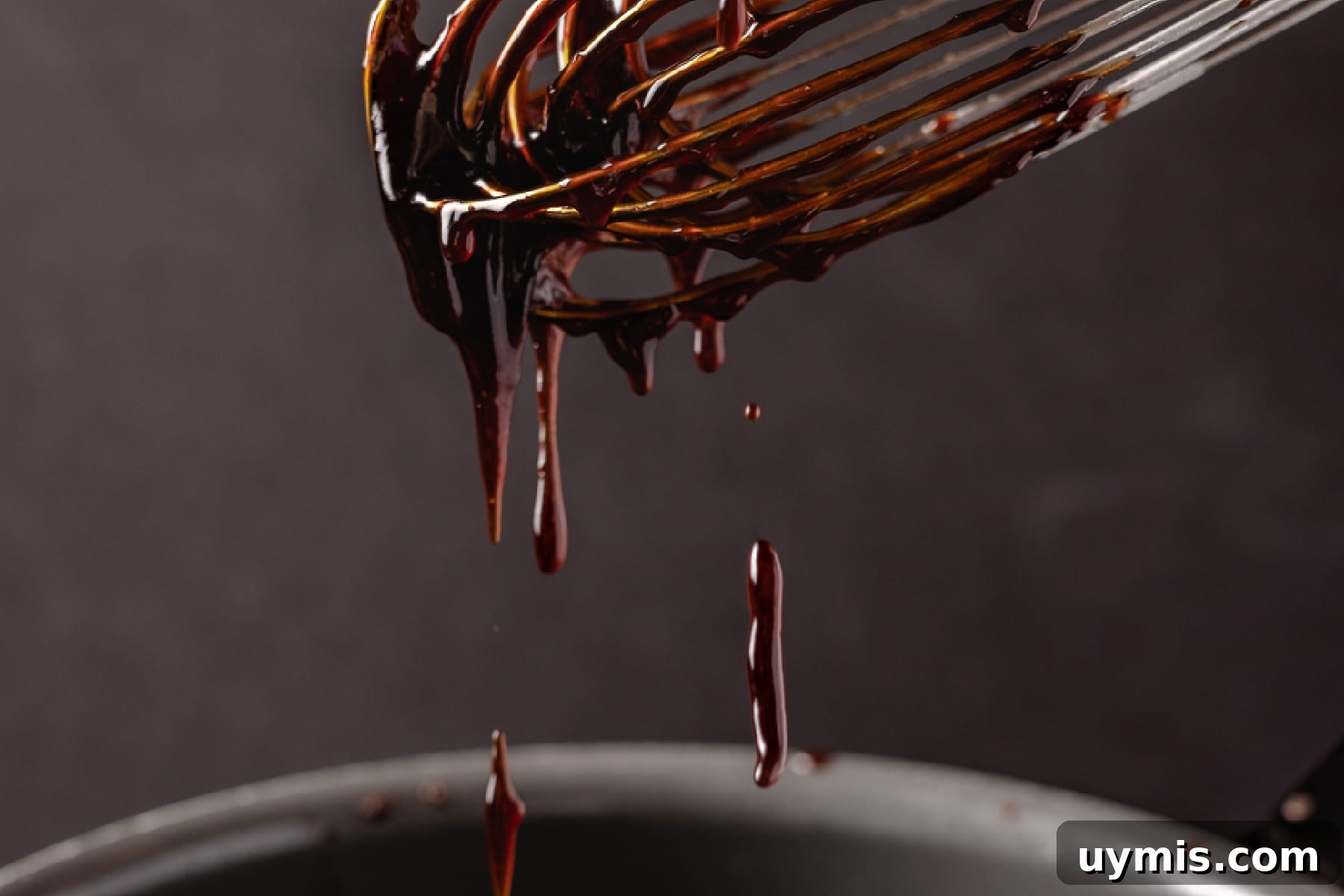 Homemade Korean BBQ Sauce Recipe 4 Korean BBQ sauce on whisk dripping into metal bowl.