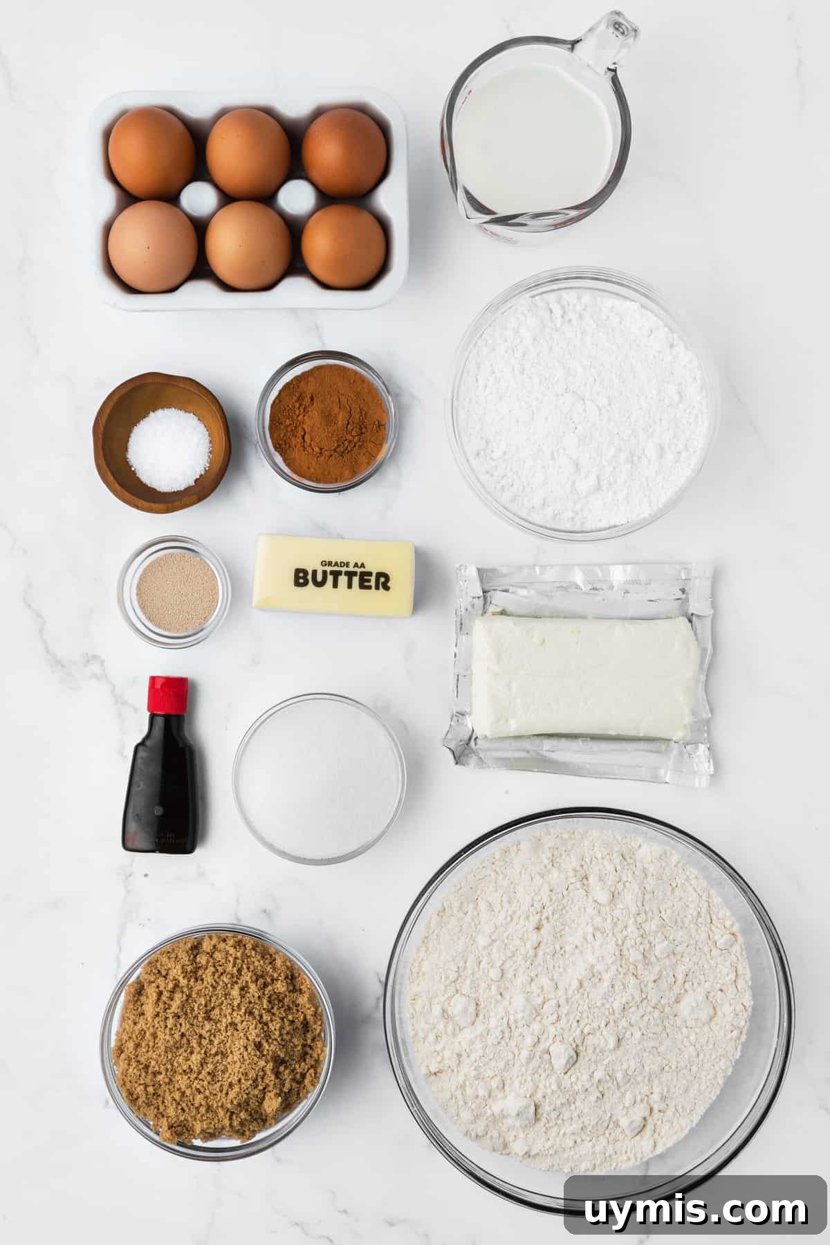 The ingredients for cinnamon rolls are placed on a white surface.