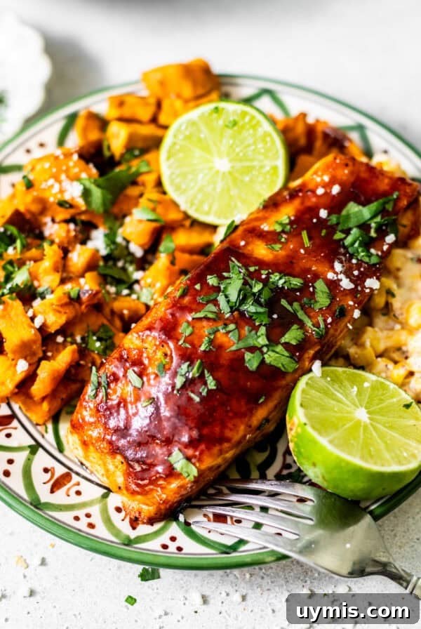 Caprese Grilled Chicken with Herb Roasted Potatoes 11 bbq salmon on a plate with sweet potatoes and corn and garnish with a lime and fresh parsley.