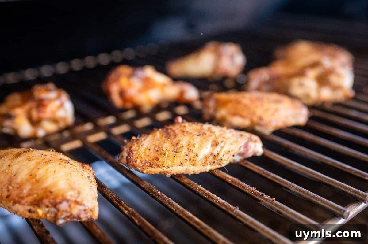 Crispy Grilled Lemon Pepper Chicken Wings Recipe 4 chicken wings grilling on a pellet grill.
