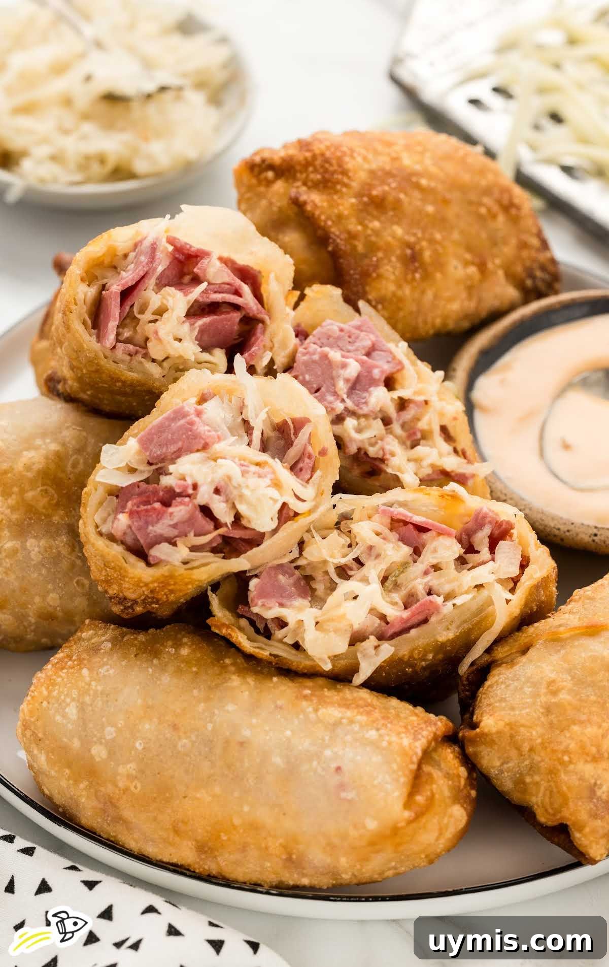 Reuben Eggrolls with a bowl of thousand island dressing on a plate